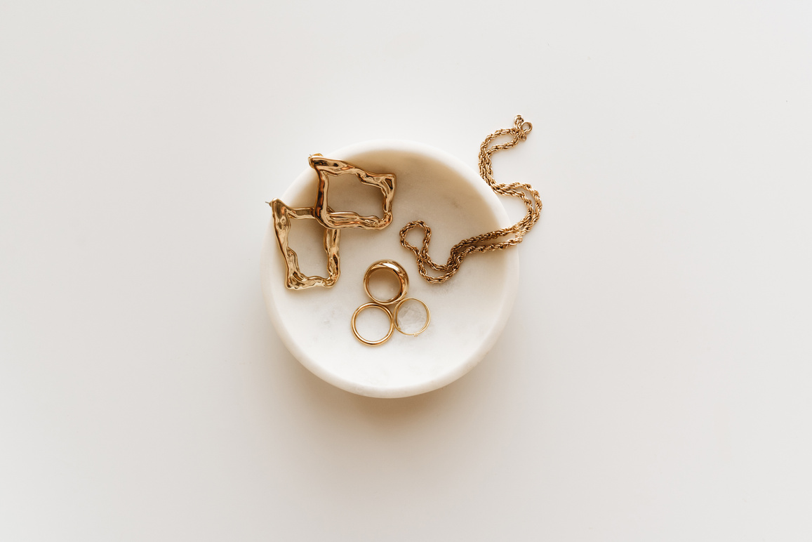 Overhead Shot of Gold Jewelry on a White Surface